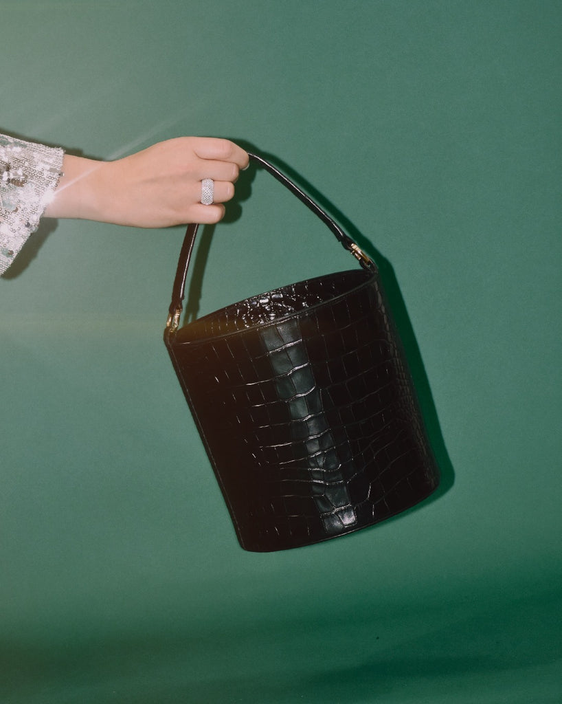 Imagen de modelo con bolso tipo cubo de piel grabada en coco negro Leandra 