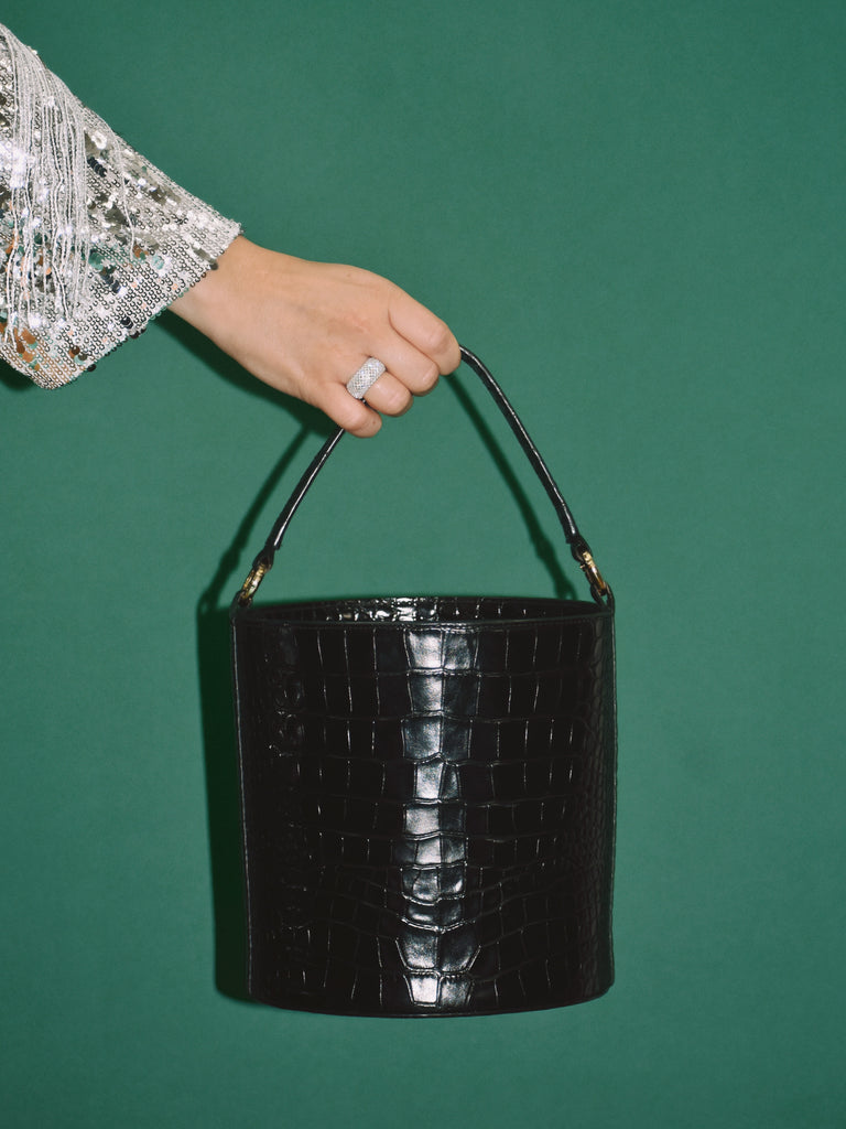 Imagen de modelo con bolso tipo cubo de piel grabada en coco negro Leandra 