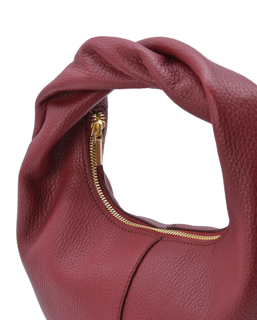 Imagen detalle de bolso hobo mini de mano de piel color burdeos Leandra. Bolsos de piel fabricados en Ubrique Made in Spain