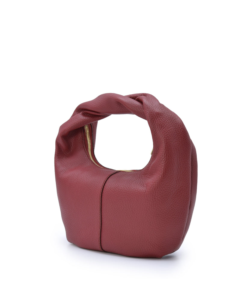 Imagen oblicua de bolso hobo mini de mano de piel color burdeos Leandra. Bolsos de piel fabricados en Ubrique Made in Spain