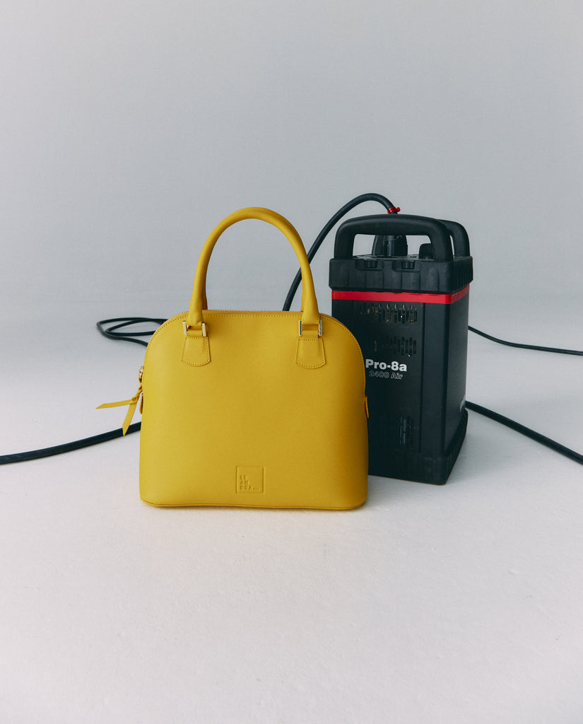 Imagen bodegón de bolso de mano de mujer de piel color amarillo fabricado en Ubrique, España Leandra a la venta en leandrabrand.com fabricado en Ubrique, España