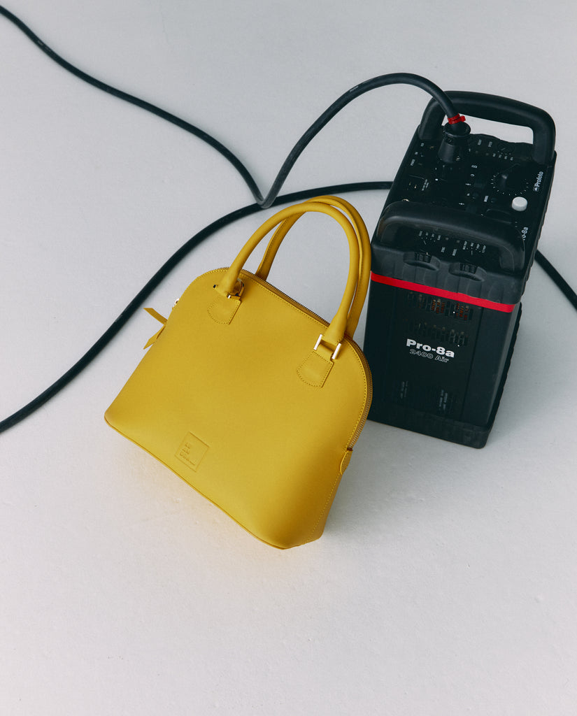 Imagen bodegón de bolso de mano de piel color amarillo fabricado en Ubrique, España Leandra a la venta en leandrabrand.com fabricado en Ubrique, España