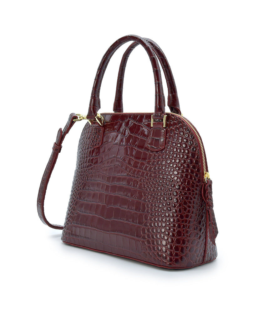 Imagen lateral de bolso de mano de piel grabada en coco color burdeos Leandra.
