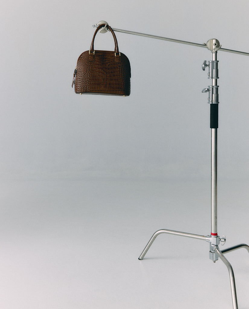 Imagen bodegón 2 de bolso de mano de piel grabada en coco color marrón Leandra. Fabricado en Ubrique, España