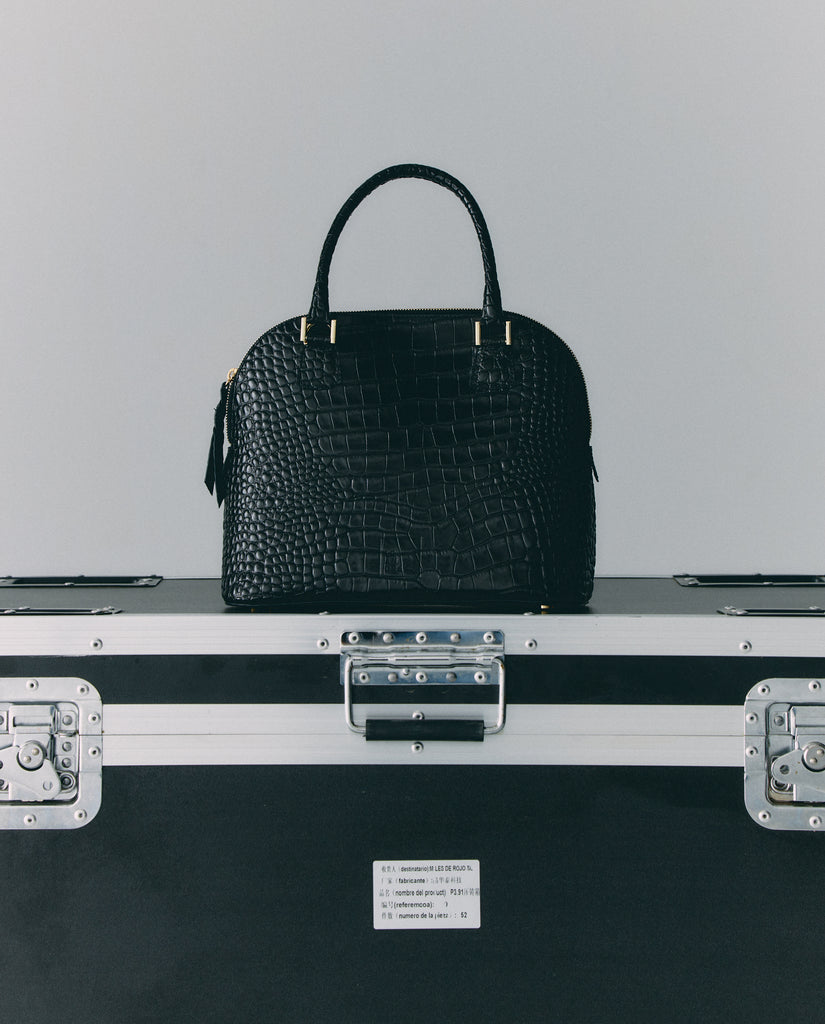 Imagen bodegón de bolso de mano de piel grabada en coco color negro Leandra. Fabricado en España