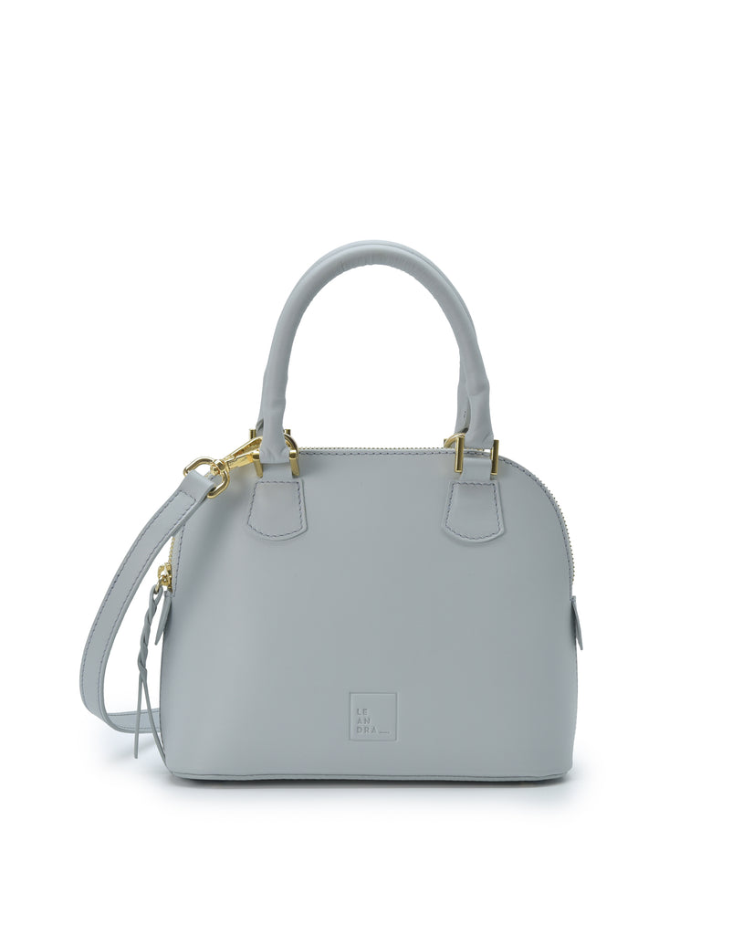 Imagen frontal con doble asa de mano del bolso de mano mini de piel color azul cielo Leandra. Bolsos de piel fabricados en Ubrique Made in Spain