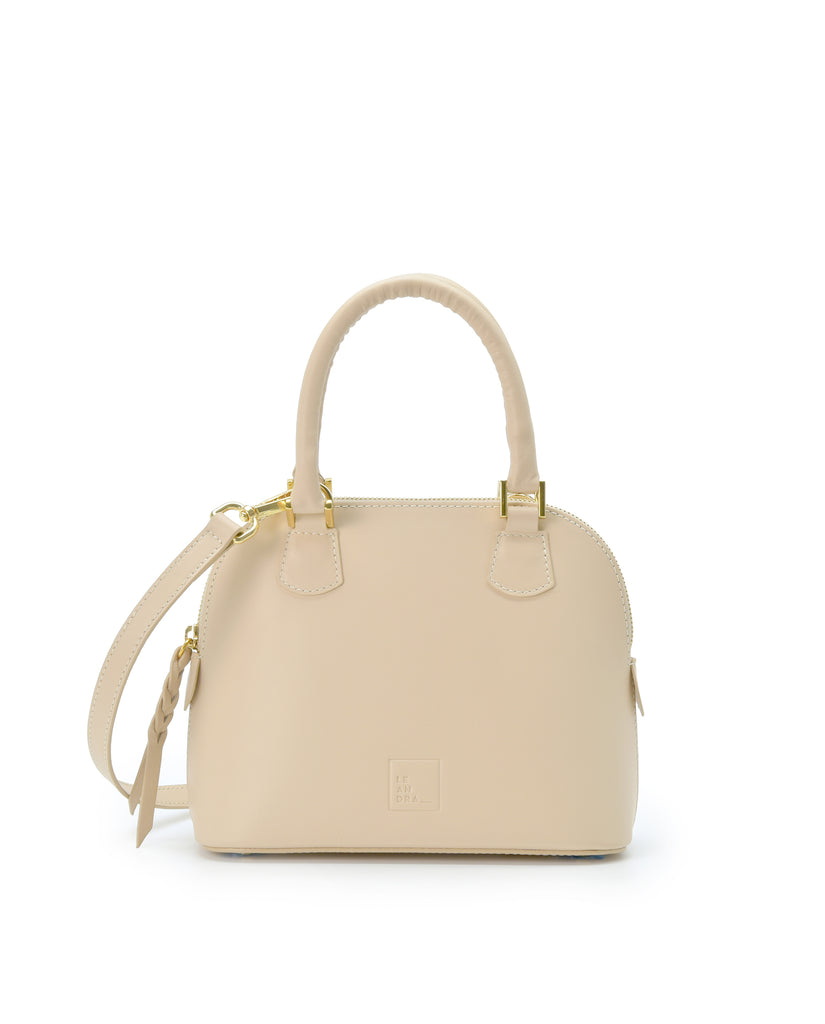 Imagen frontal con doble asa de mano del bolso de mano mini de piel color beige Leandra. Bolsos de piel fabricados en Ubrique Made in Spain