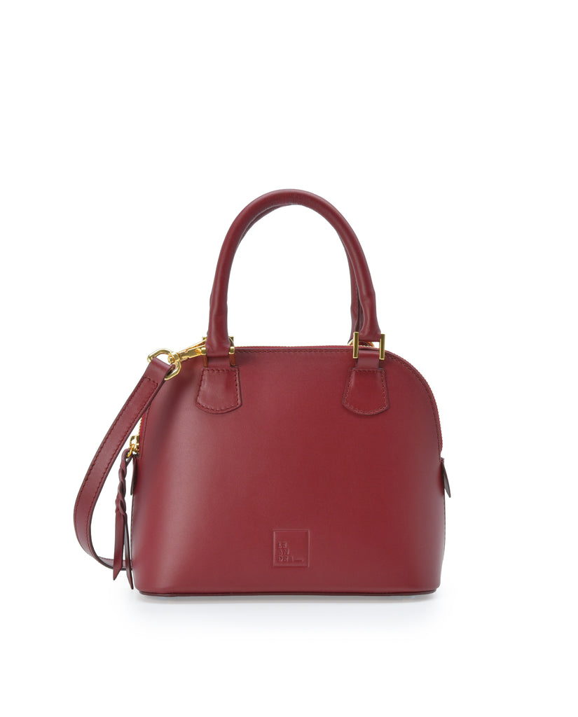 Imagen frontal con doble asa de mano del bolso de mano mini de piel color burdeos Leandra. Bolsos de piel fabricados en Ubrique Made in Spain