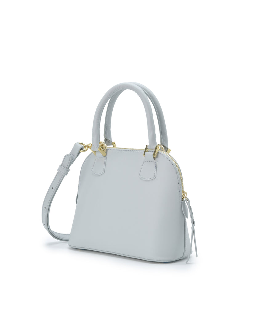 Imagen lateral de bolso de mano mini de piel color azul cielo Leandra. Bolso made in Spain