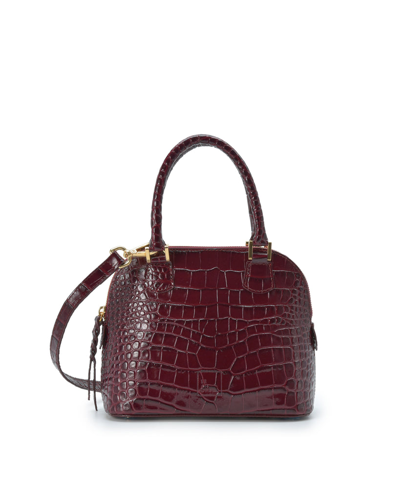 Imagen frontal con doble asa de bolso de mano mini de piel grabada en coco color burdeos Leandra. Made in Spain