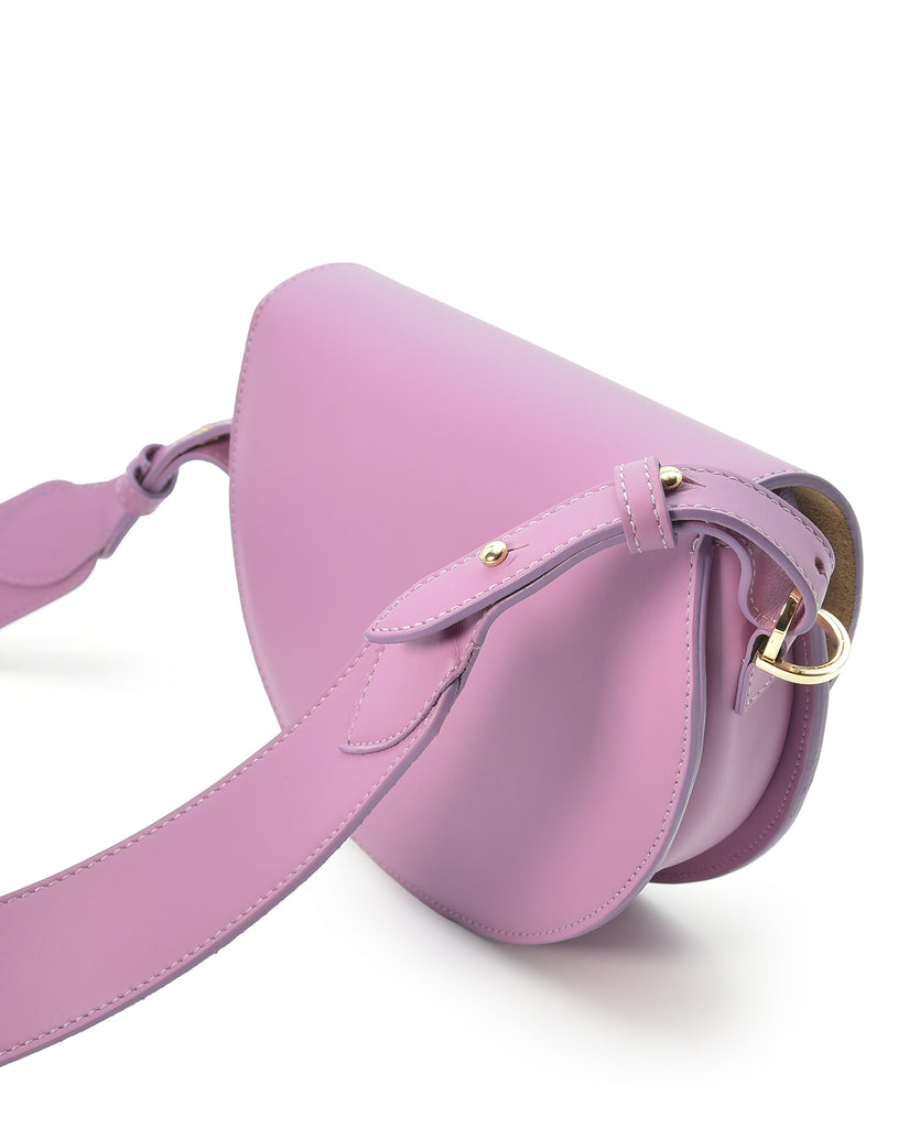 Imagen lateral de bolso de piel de mujer tipo bandolera Saddle bag en color lila. Bolso fabricado en Ubrique, España a la venta en leandrabrand.com