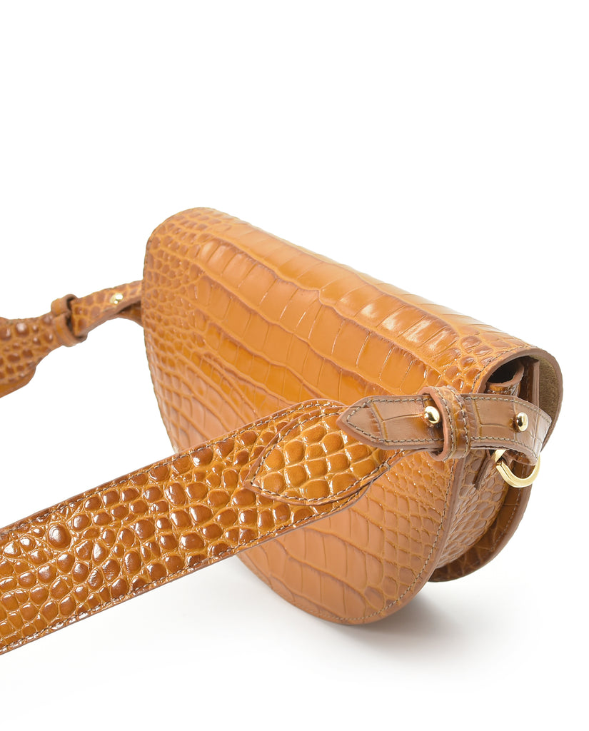 Imagen lateral de bolso de mujer de piel camel tipo bandolera Saddle bag de piel grabada en coco camel Leandra fabricado en Ubrique, España. Bolso Made in Spain a la venta en leandrabrand.com