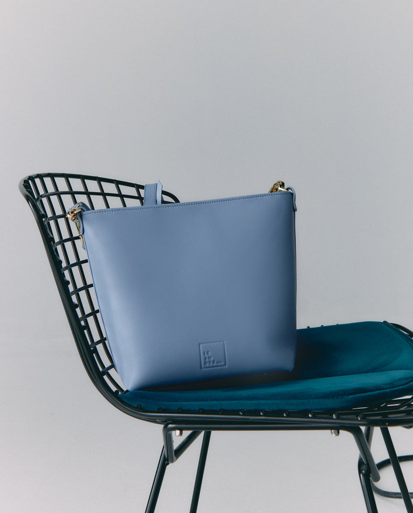 Imagen bolso en silla 2 de bolso mujer estilo tote bag multiposición de piel color azul Leandra. Fabricado en Ubrique, España. 