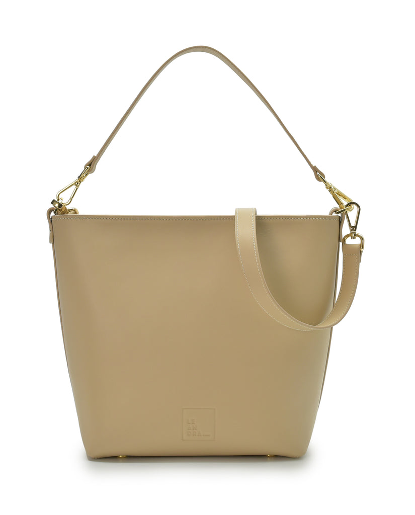 Imagen frontal de bolso de hombro beige tipo tote bag multiposición de piel color beige Leandra. Bolso made in Ubrique.