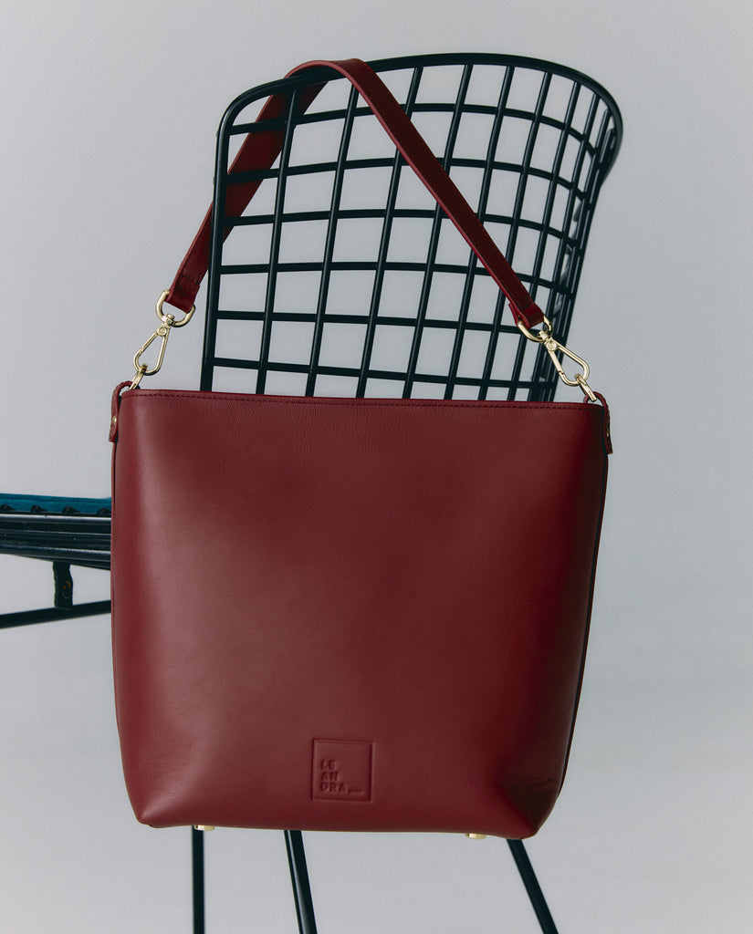 Imagen bolso en silla. Bolso de hombro tipo tote bag multiposición de piel color burdeos Leandra. Made in Spain. 