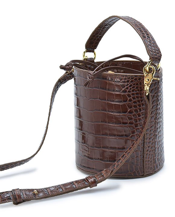 Imagen lateral de bolso tipo Bucket de piel grabada en coco marrón fabricado en Ubrique Leandra. 