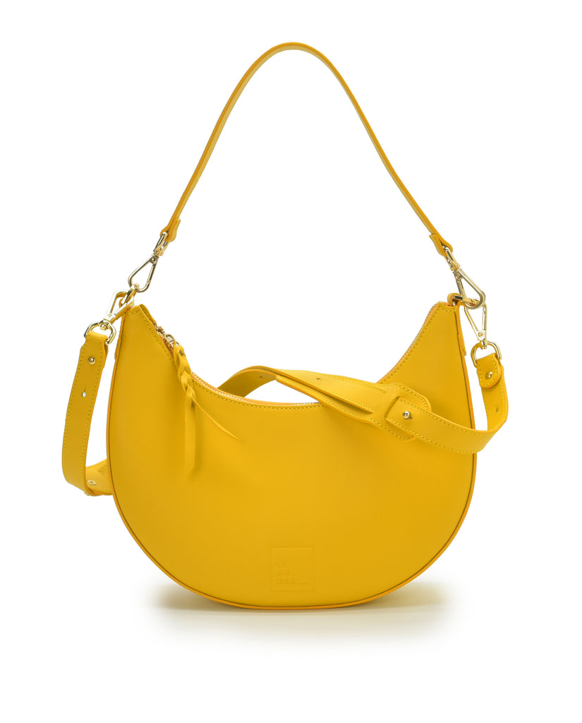 Bolso de hombro multiposición con forma de media luna de piel color amarillo Leandra. Made in Spain