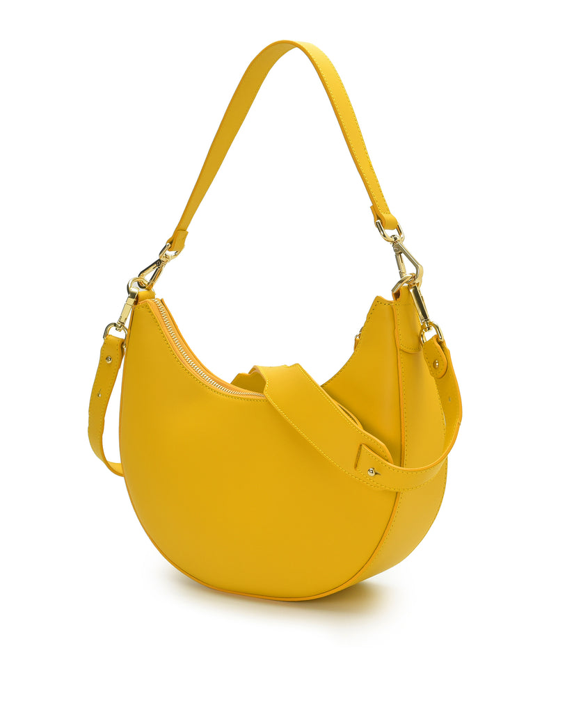 Bolso de hombro multiposición con forma de media luna de piel color amarillo Leandra. Fabricado en Ubrique, España