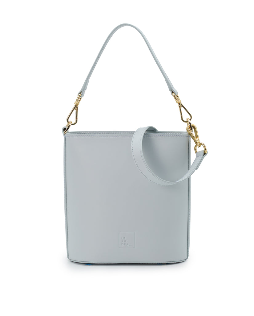 Imagen frontal de bolso bucket multiposición de piel color azul cielo con cremallera Leandra. Bolso made in Spain