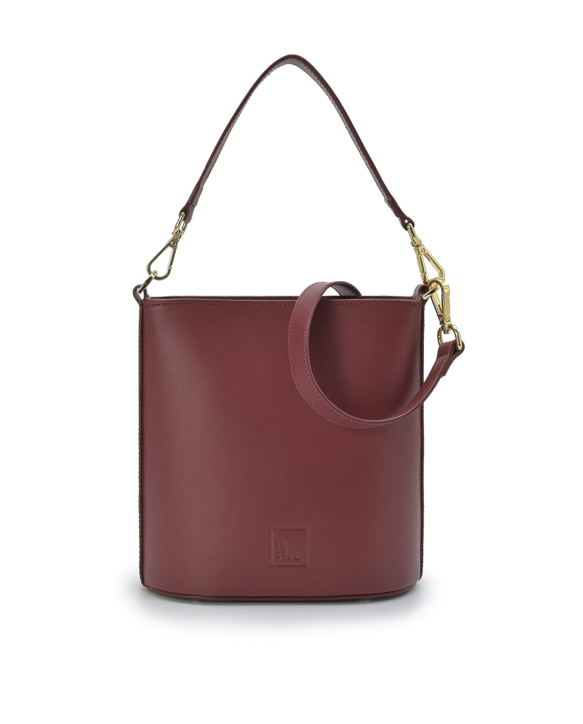 Imagen frontal de bolso bucket multiposición de piel color burdeos con cremallera Leandra. Bolso made in Spain