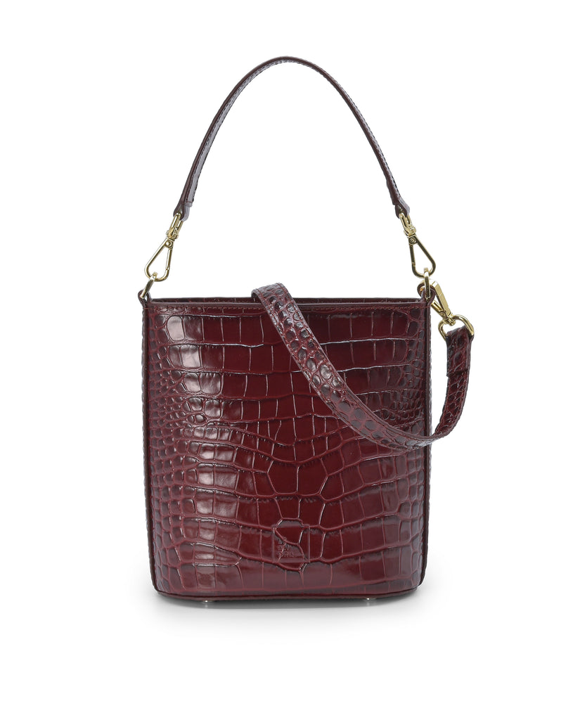 Imagen frontal de bolso bucket multiposición de piel grabada en coco color burdeos con cremallera Leandra. Bolso made in Spain