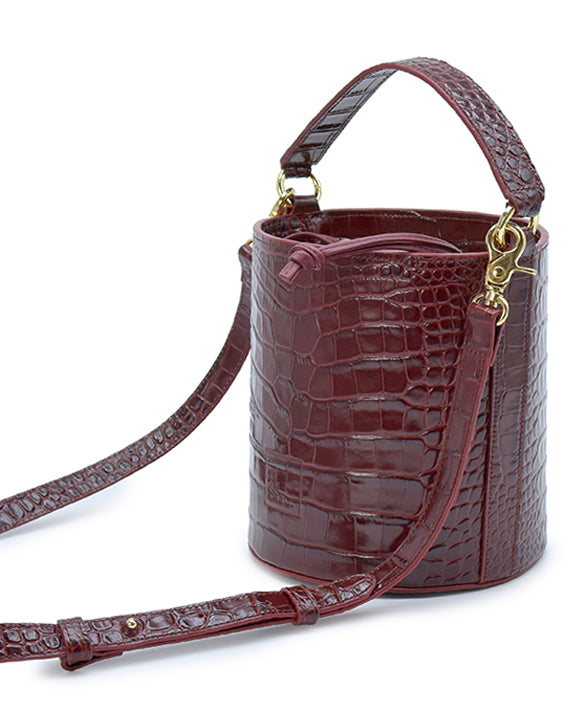 Imagen lateral de bolso bucket de piel grabada en coco burdeos fabricado en España Leandra