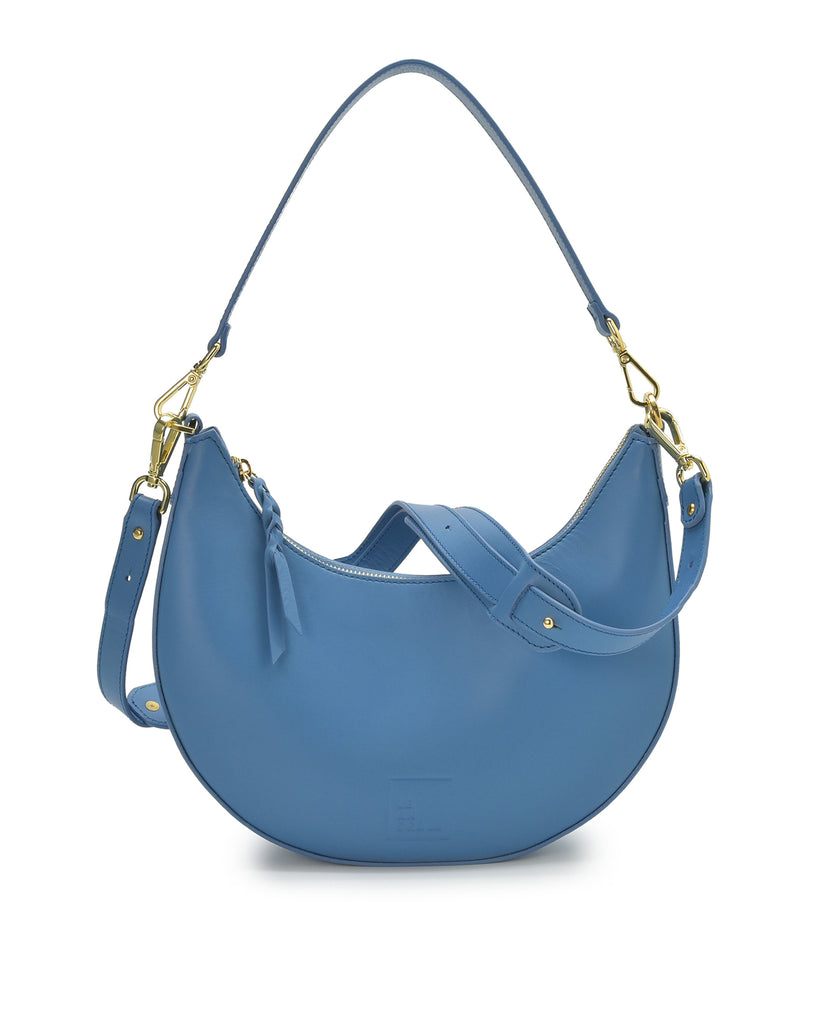Imagen asa doble de bolso media luna de piel de hombro multiposición con forma de media luna de piel color azul Leandra. Made in Spain 