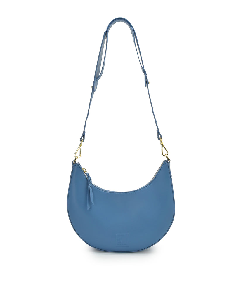 Imagen asa larga de bolso media luna de piel color azul Leandra. Bolso de hombro multiposición made in Spain Leandra.