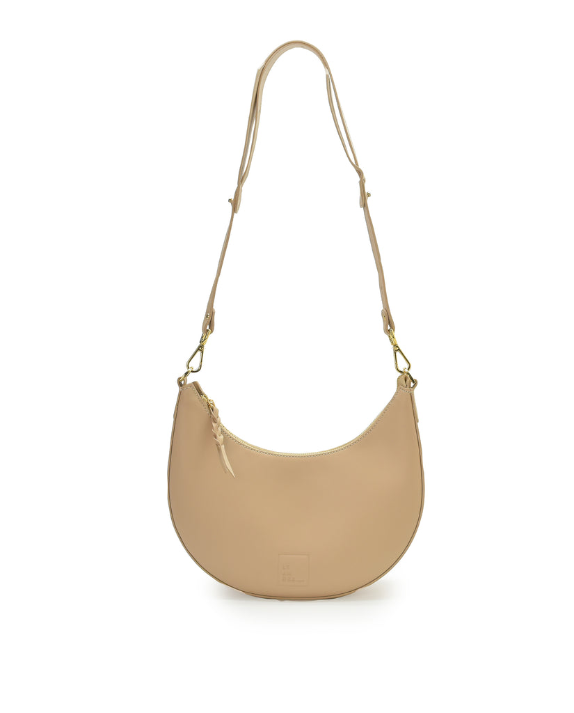 Imagen asa larga de bolso media luna beige Leandra. Bolso de hombro multiposición con forma de media luna de piel color beige Leandra. Fabricado en Ubrique España