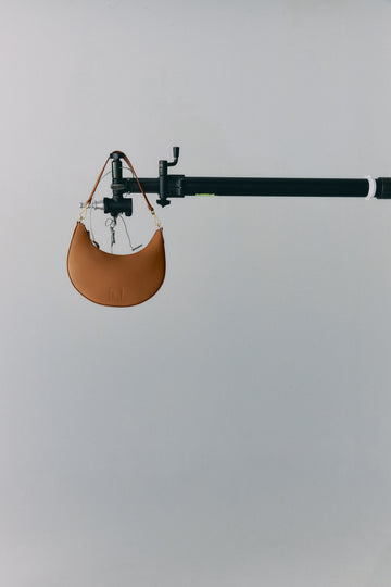 Imagen bolso media luna camel. Bolso de hombro multiposición con forma de media luna de piel color negro made in Spain Leandra