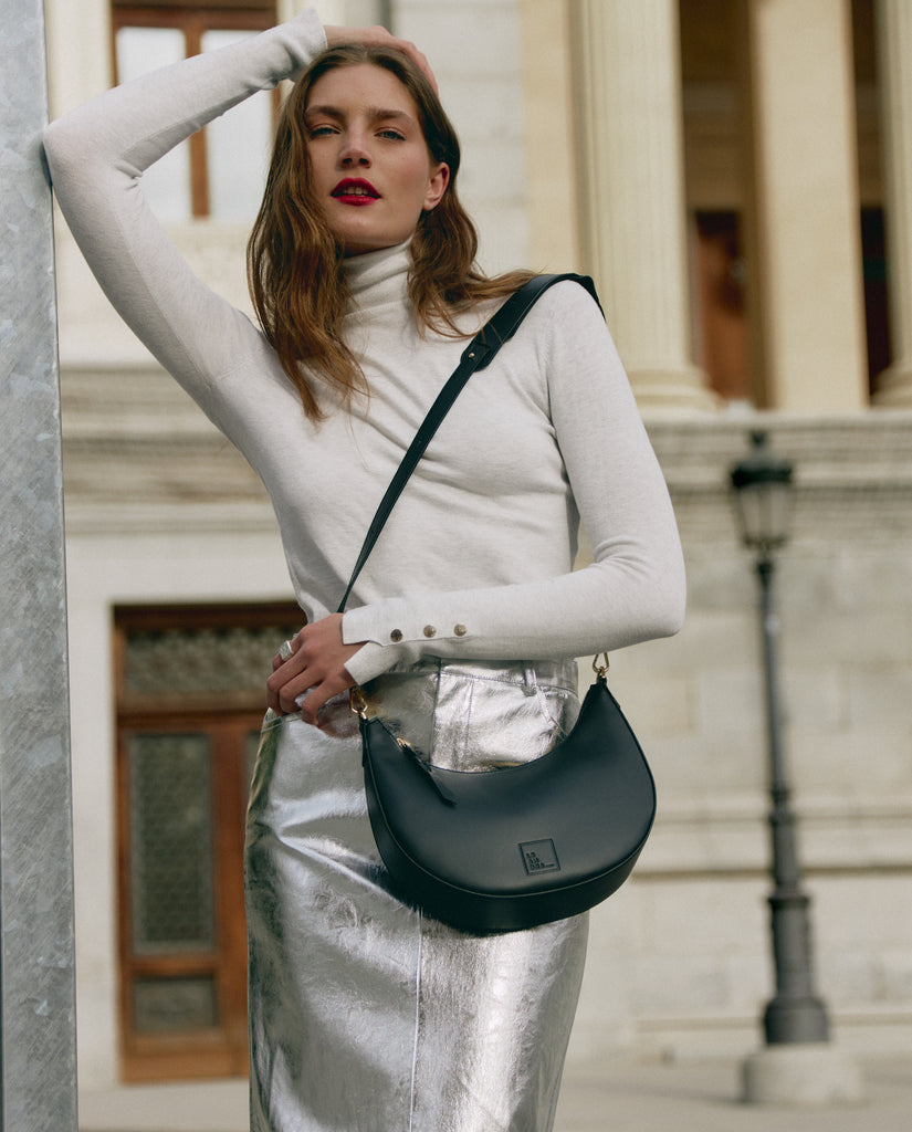 Bolso de hombro multiposición con forma de media luna de piel color negro Leandra. Imagen modelo 