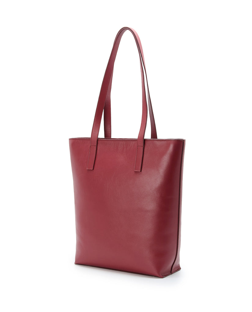 Imagen lateral de bolso shopper multiposición de piel color burdeos con cremallera Leandra. Bolso made in Spain