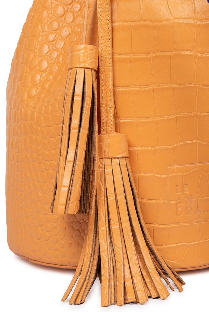 Detalle borla Bucket bag de piel grabada en coco color pomelo Leandra. Bolsos de piel made in Spain imagen detalle borla