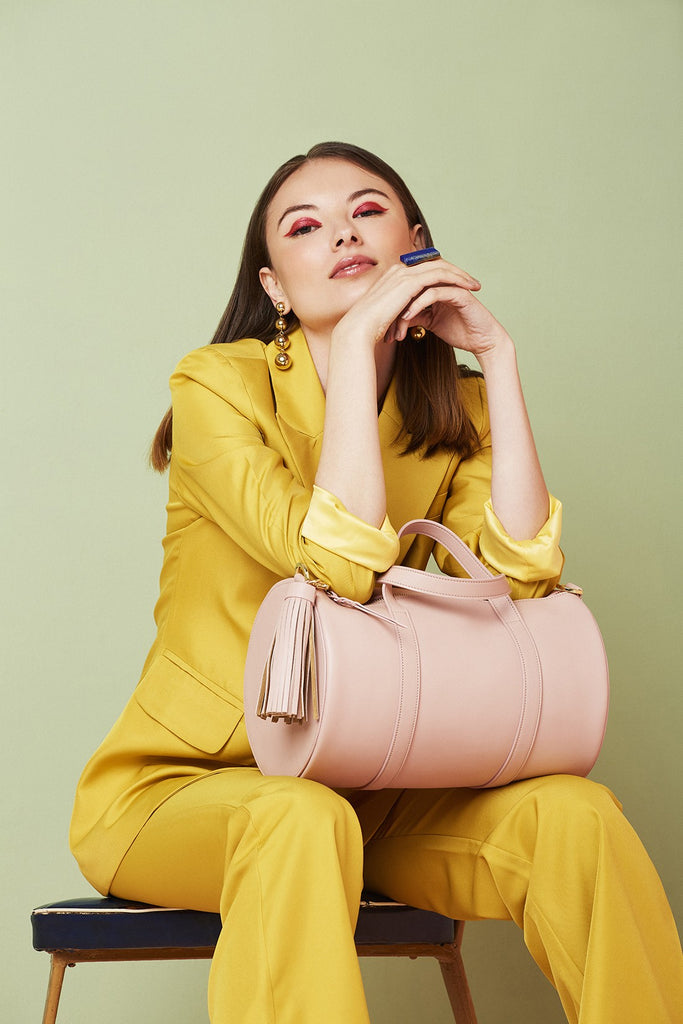 Imagen modelo sentada con bolso tipo bowling de piel rosa Leandra. Bolso bowling de piel made in Spain Leandra