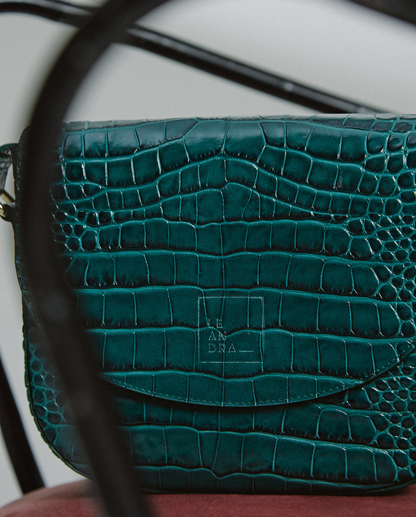 Imagen bodegón de bolso bandolera de piel grabada en coco verde Leandra fabricada en Ubrique y a la venta en leandrabrand.com