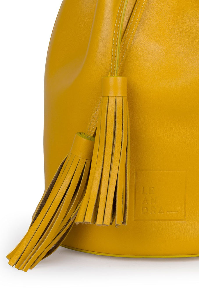 Imagen detalle borlas de bolso saco piel amarillo mostaza Leandra. Bolso de piel Made in Spain Leandra