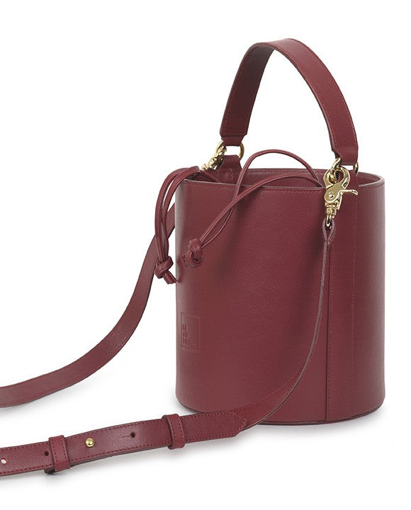 Bolso burdeos bucket de piel Leandra con asa de mano y asa bandolera. Bolso de piel made in Spain Leandra. Imagen asa extendida.