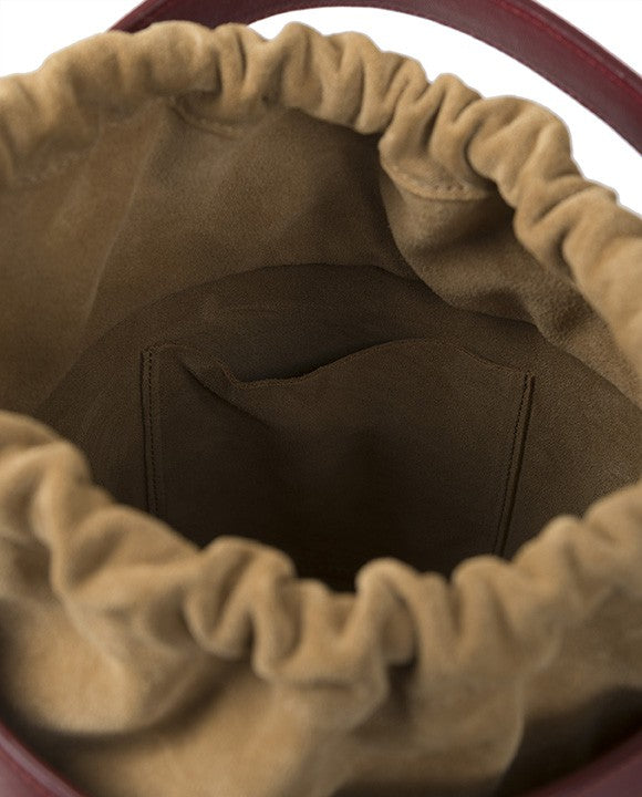 Bucket burdeos de piel Leandra con asa de mano y asa bandolera. Bolso de piel made in Spain Leandra. Imagen interior bolso.