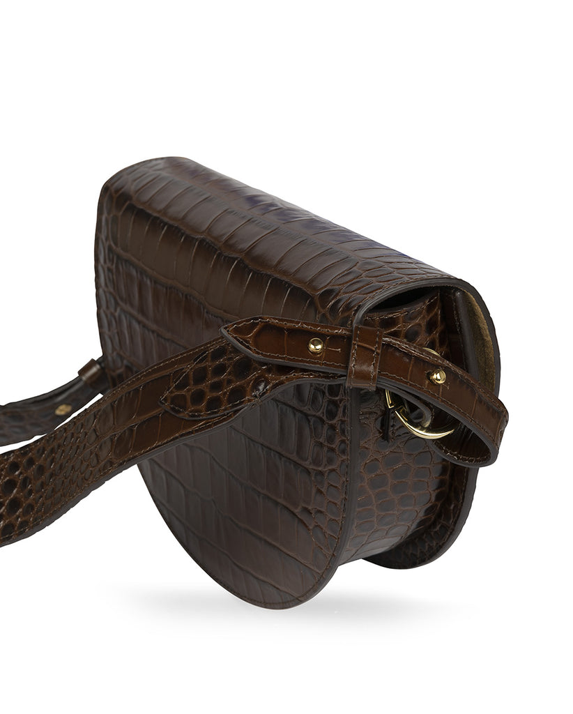 Imagen lateral de Bolso tipo saddle bag de piel grabada en coco color marrón oscuro Leandra. Bolso piel made in Spain Leandra