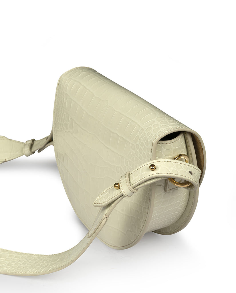 Imagen lateral de bolso tipo saddle bag de piel grabada en coco color roto Leandra. Bolso de mano con asa bandolera de piel made in Spain Leandra