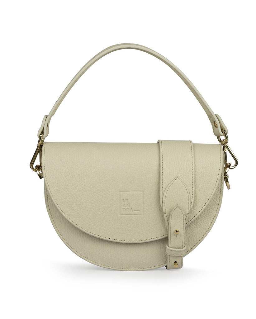 Imagen frontal de bolso saddle bag de piel con grano color crema Leandra. Bolsos beige de piel made in Spain Leandra