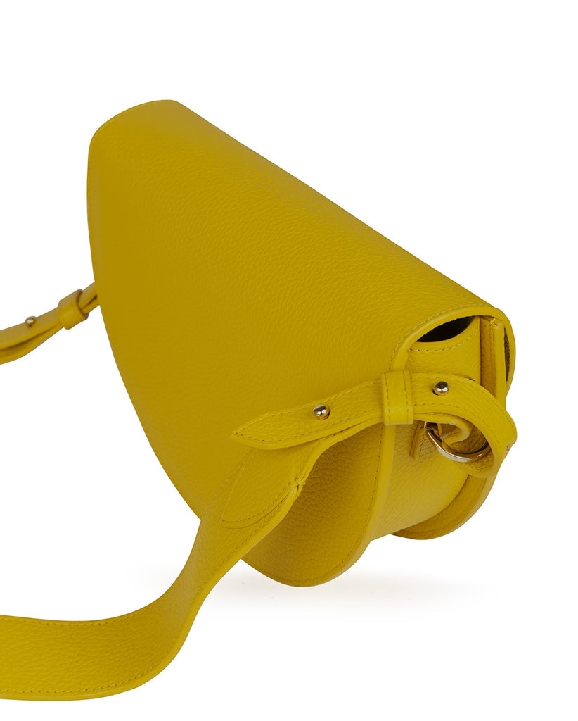 Lateral de bolso tipo Saddle bag de piel con grano amarillo mostaza Leandra. Bolso fabricado en España Leandra