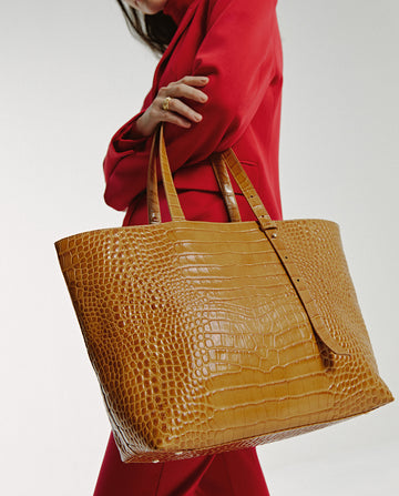 Imagen de modelo con bolso tipo shopping bag de piel grabada en coco color camel Leandra made in Spain 
