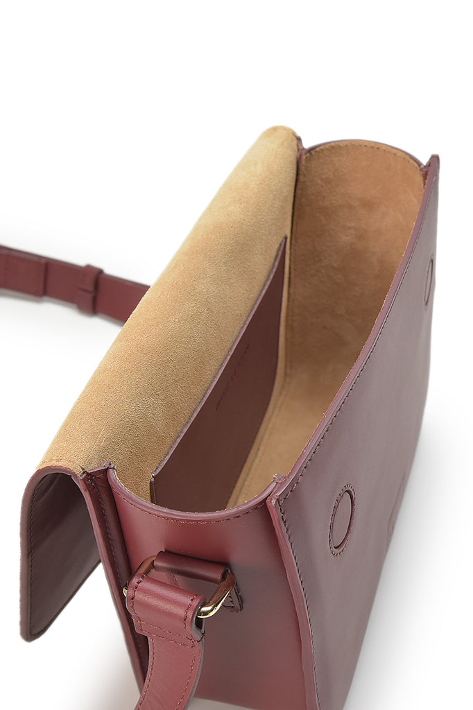Interior de bandolera rectangular con solapa de piel color burdeos Leandra a la venta en leandrabrand.com