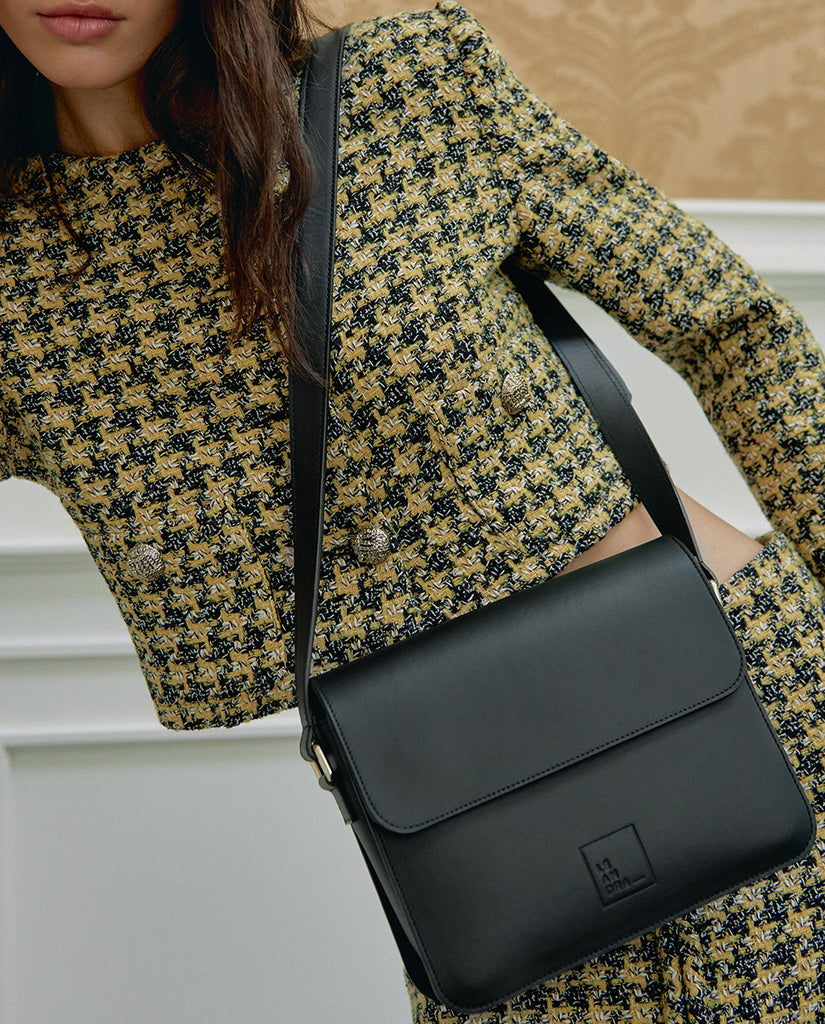 Bandolera Leandra de piel con forma rectangular y solapa de piel color negro Leandra