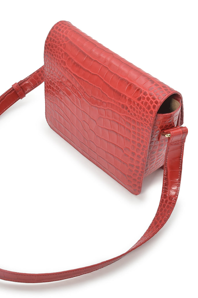 Imagen oblicua de bandolera rectangular con solapa de piel grabada en coco rojo Leandra made in Spain