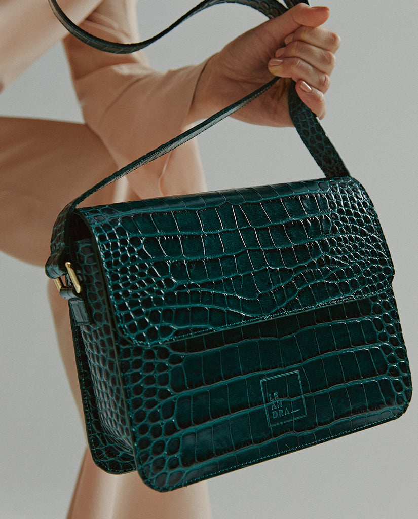 Imagen modelo con bolso bandolera rectangular con solapa de piel grabada en coco verde Leandra.