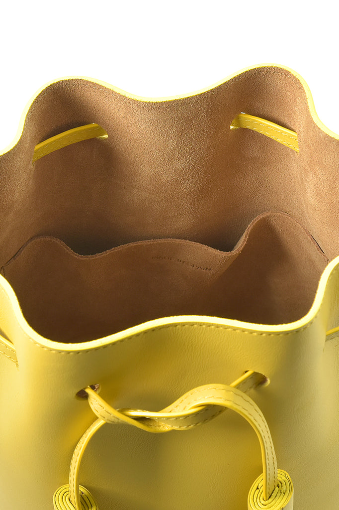 Mini bolso de piel tipo saco o Mini bucket bag color amarillo con borlas bicolor en nude Leandra. Bolso de piel Leandra color amarillo Leandra imagen detalle bolsillo interior. 