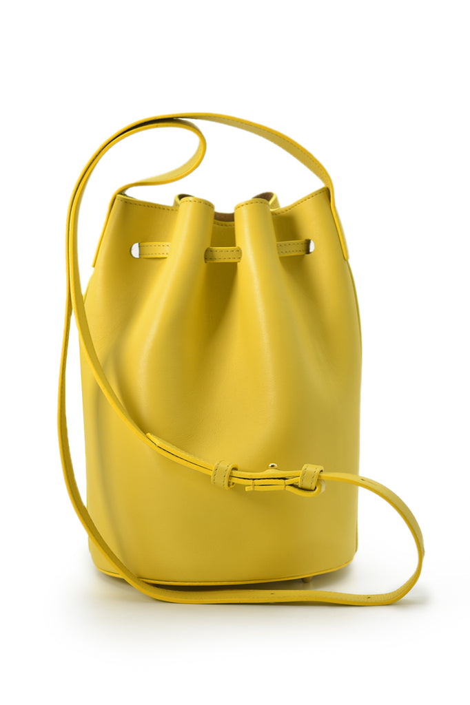 Mini bolso de piel tipo saco o Mini bucket bag color amarillo con borlas bicolor en nude Leandra imagen trasera