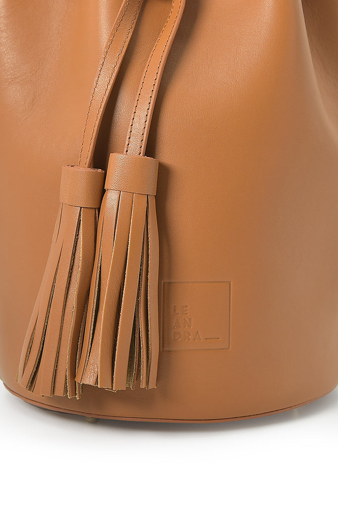 Mini bucket bag de piel color caramel Leandra. Bolsos Made in Spain Leandra imagen detalle borla